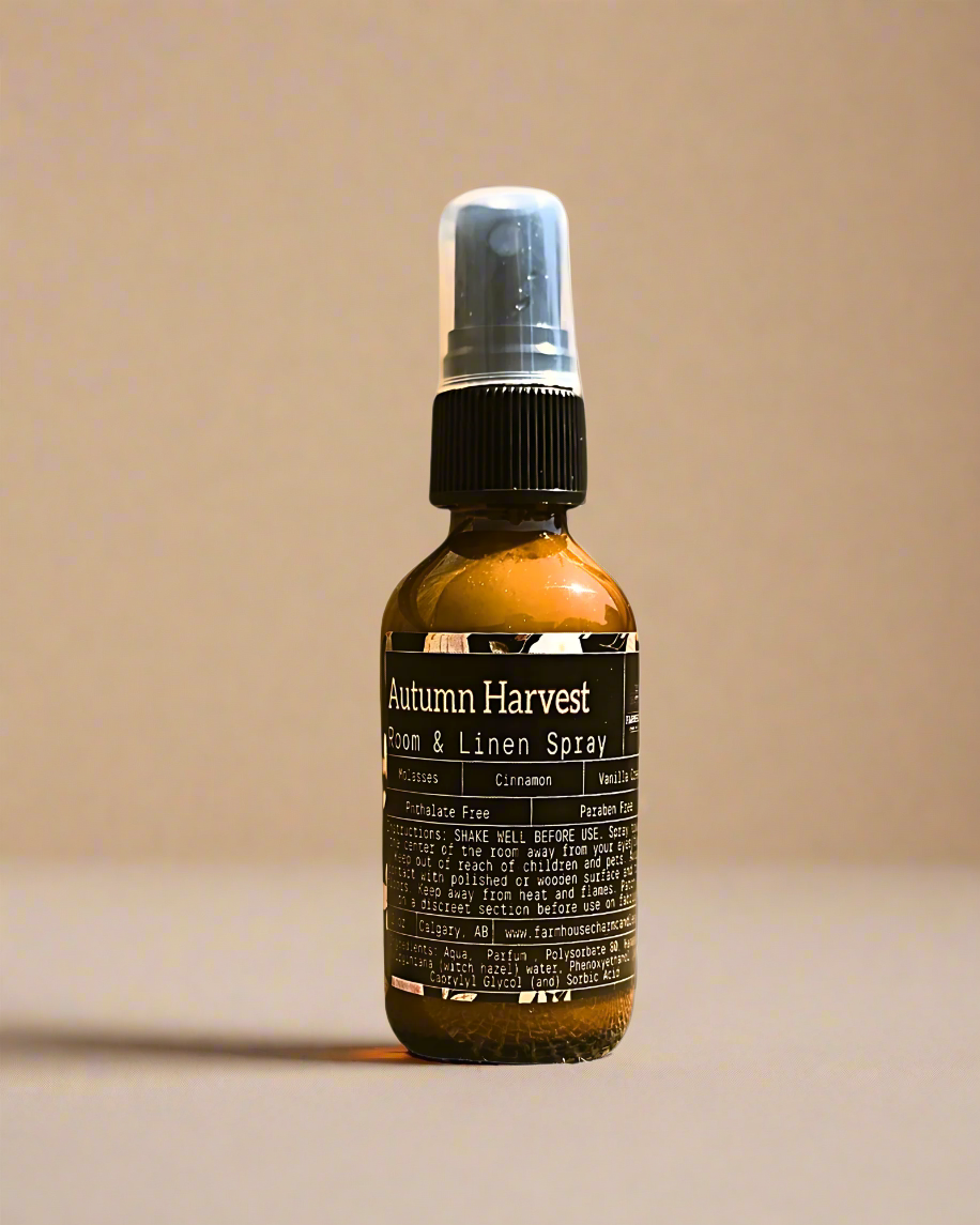 Bottle of Autumn Harvest room and linen spray by Farmhouse Charm Candles on a beige background