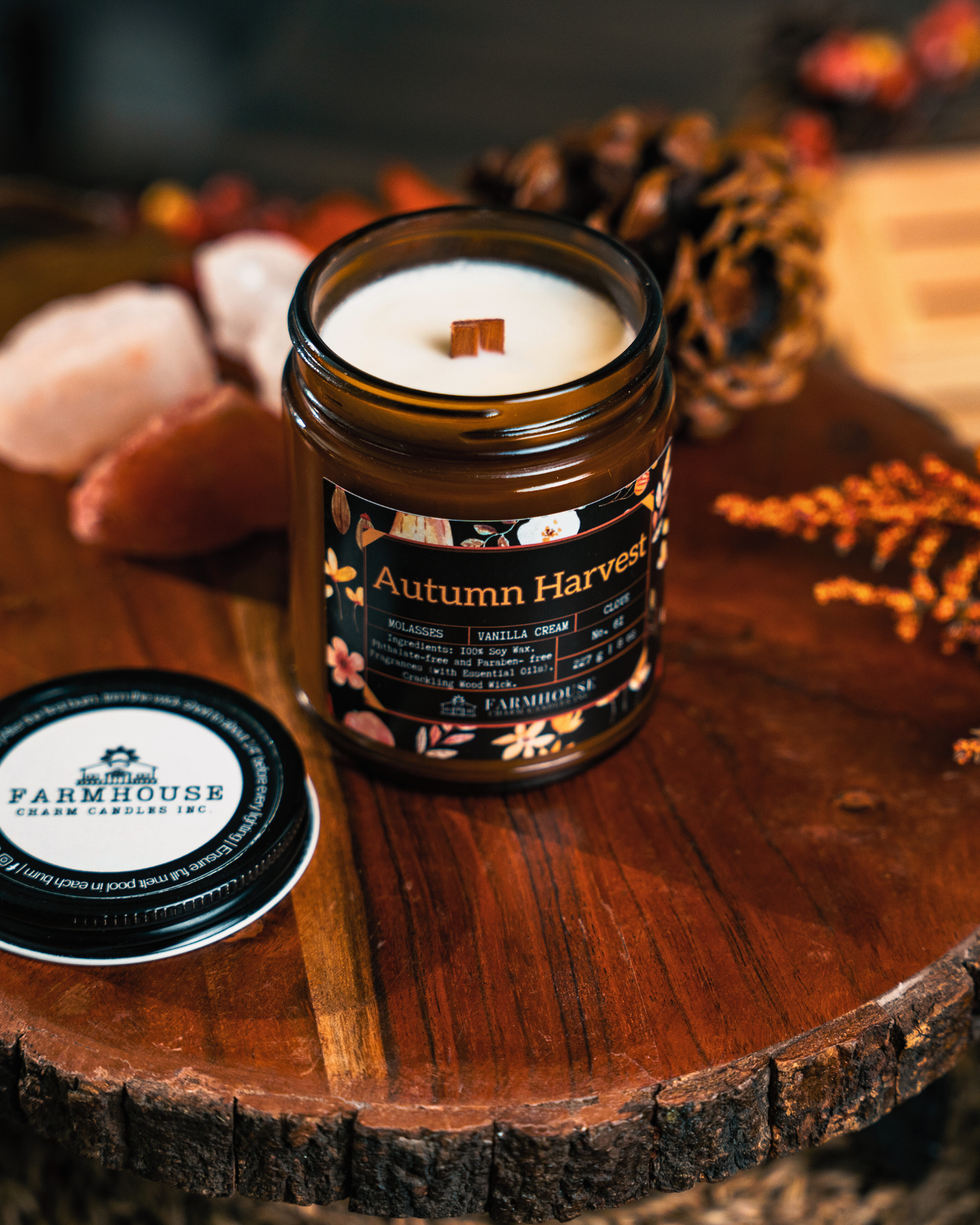 Autumn Harvest soy candle by Farmhouse Charm Candles in a glass jar on a wooden surface with fall decorative elements.