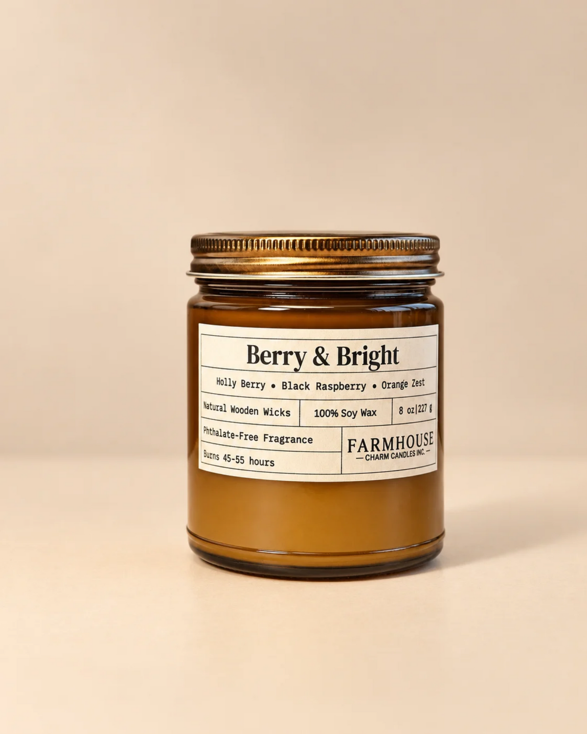 A Farmhouse Charm Candles 'Berry & Bright' scented soy wax candle in an amber glass jar with a rustic gold metal lid, set against a solid beige background.