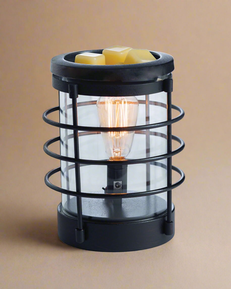 An updated traditional style with wire framing in a matte black finish give this Vintage Bulb Illumination a classic lantern feel. Illumination Fragrance Warmers use a Vintage Bulb to warm wax melts in the dish, releasing their fragrance. Suggested Use: Simply add wax melts to the dish, turn it on, and enjoy your favorite fragrance as it spreads through the room. This warmer works beautifully with 100% Soy Wax Melts by Farmhouse Charm Candles Inc.