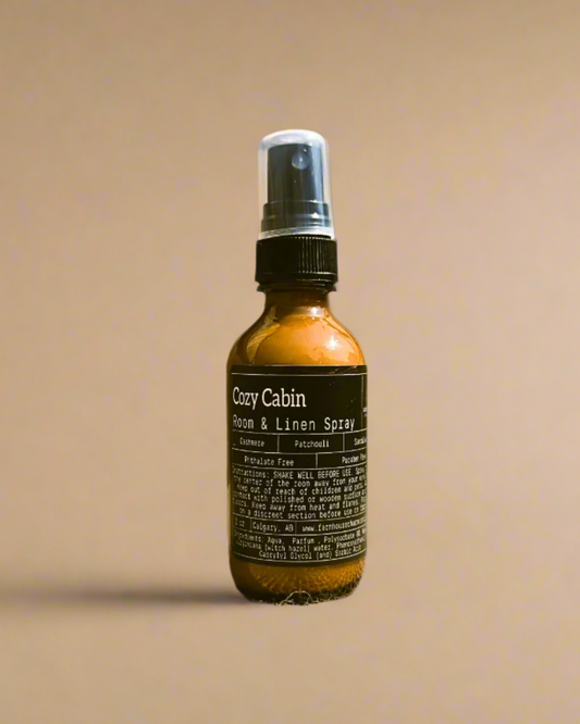 Cozy Cabin room and linen spray bottle by Farmhouse Charm Candles on a beige background