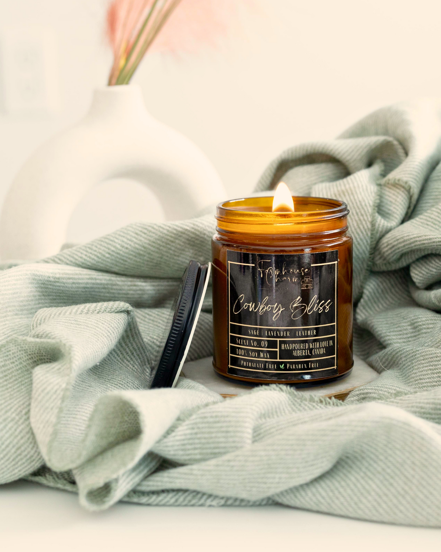 Experience the pleasure of Cowboy Bliss soy candle's aroma. Immerse yourself in the one-of-a-kind blend of wood sage, soft lavender, and leather. The fragrance provides an ideal balance of floral and subtle woody undertones that captivate the senses. As you light up the Cowboy Bliss soy candle, the aroma will fill your space, creating an ambiance that will transport you to the beautiful countryside. www.farmhousecharmcandles.com