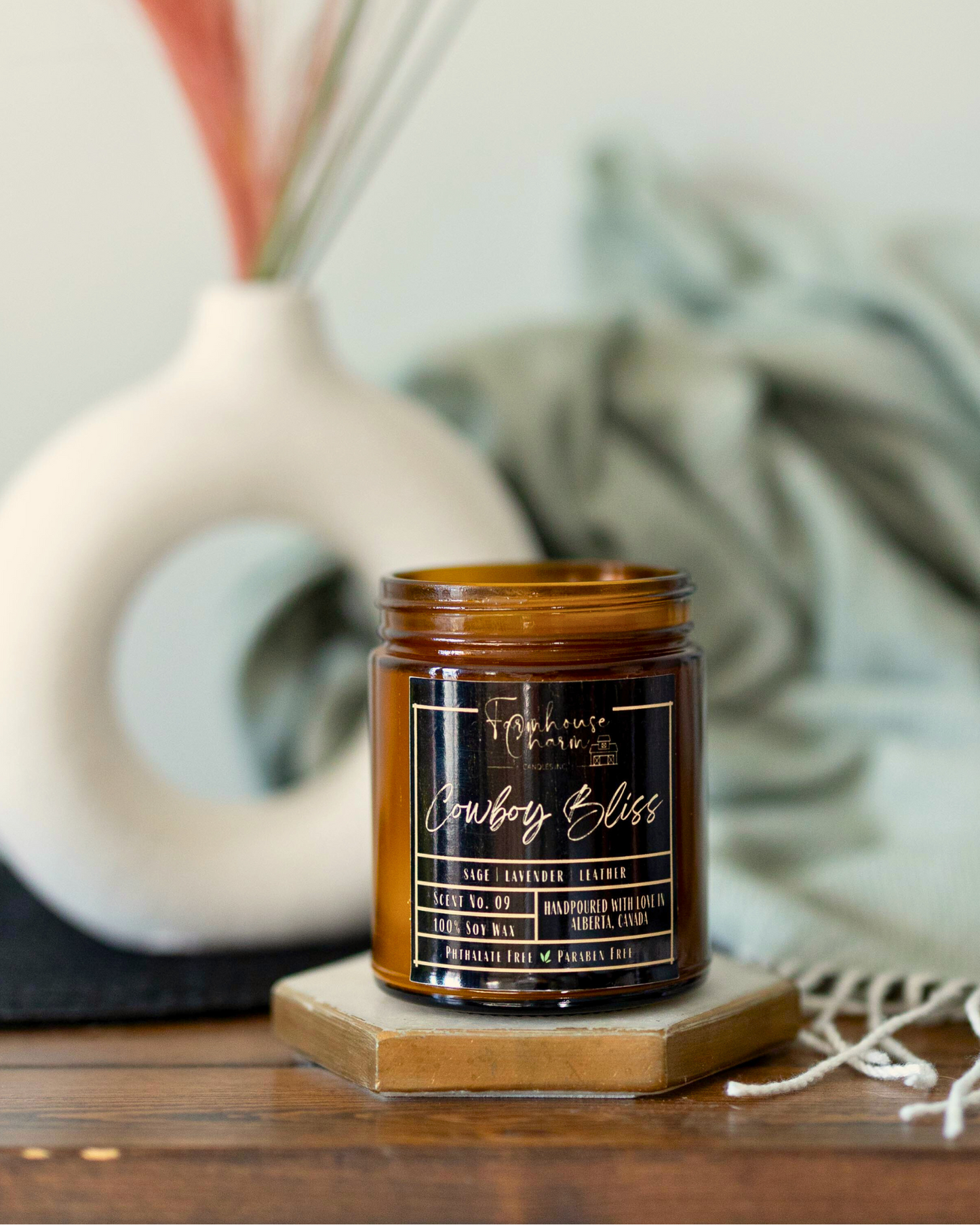 Experience the pleasure of Cowboy Bliss soy candle's aroma. Immerse yourself in the one-of-a-kind blend of wood sage, soft lavender, and leather. The fragrance provides an ideal balance of floral and subtle woody undertones that captivate the senses. As you light up the Cowboy Bliss soy candle, the aroma will fill your space, creating an ambiance that will transport you to the beautiful countryside. www.farmhousecharmcandles.com