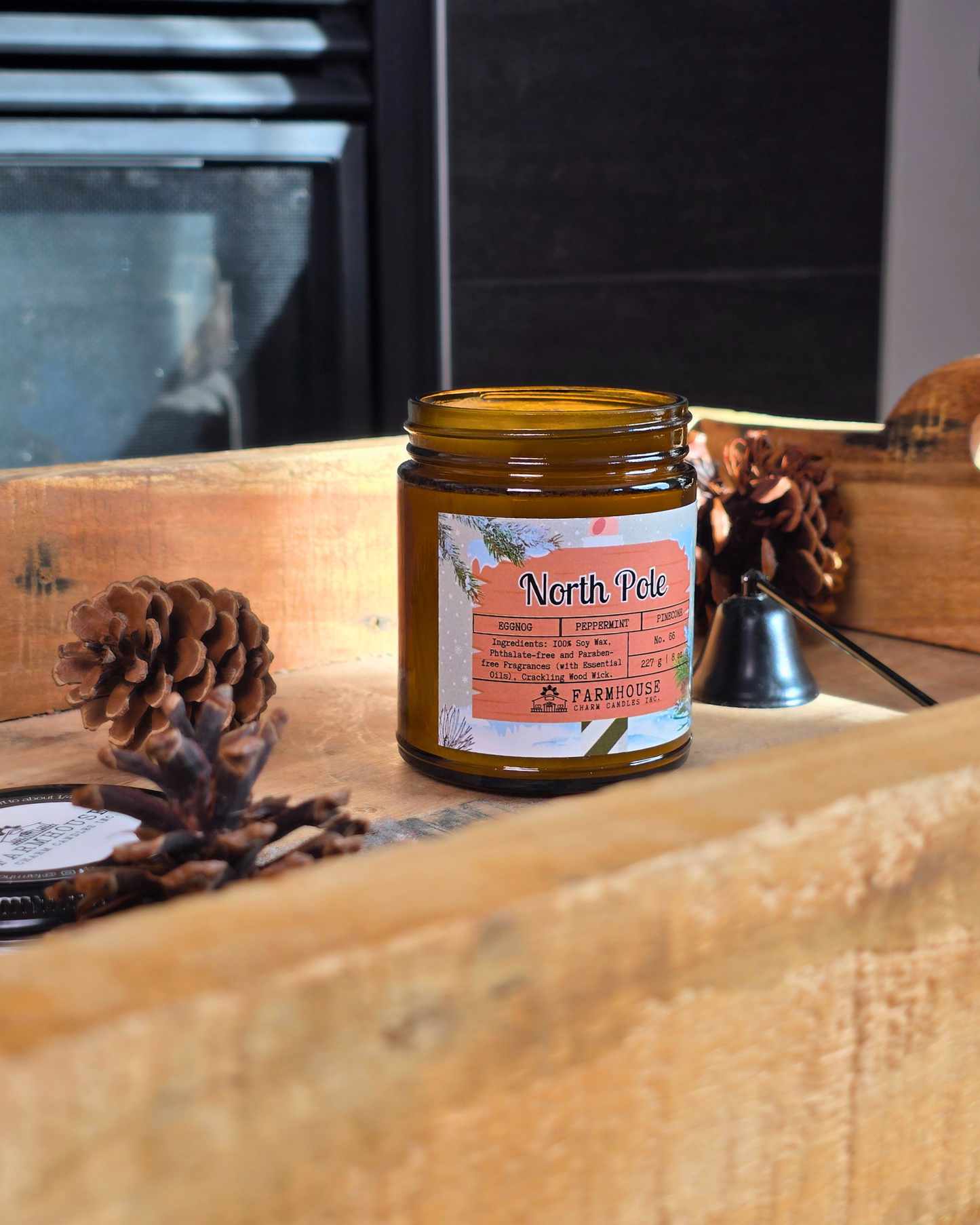 North Pole Soy Candle by Farmhouse Charm Candles — hand-poured soy candle in amber jar with a cozy holiday scent of eggnog, peppermint, and pinecone, styled with festive winter decor.