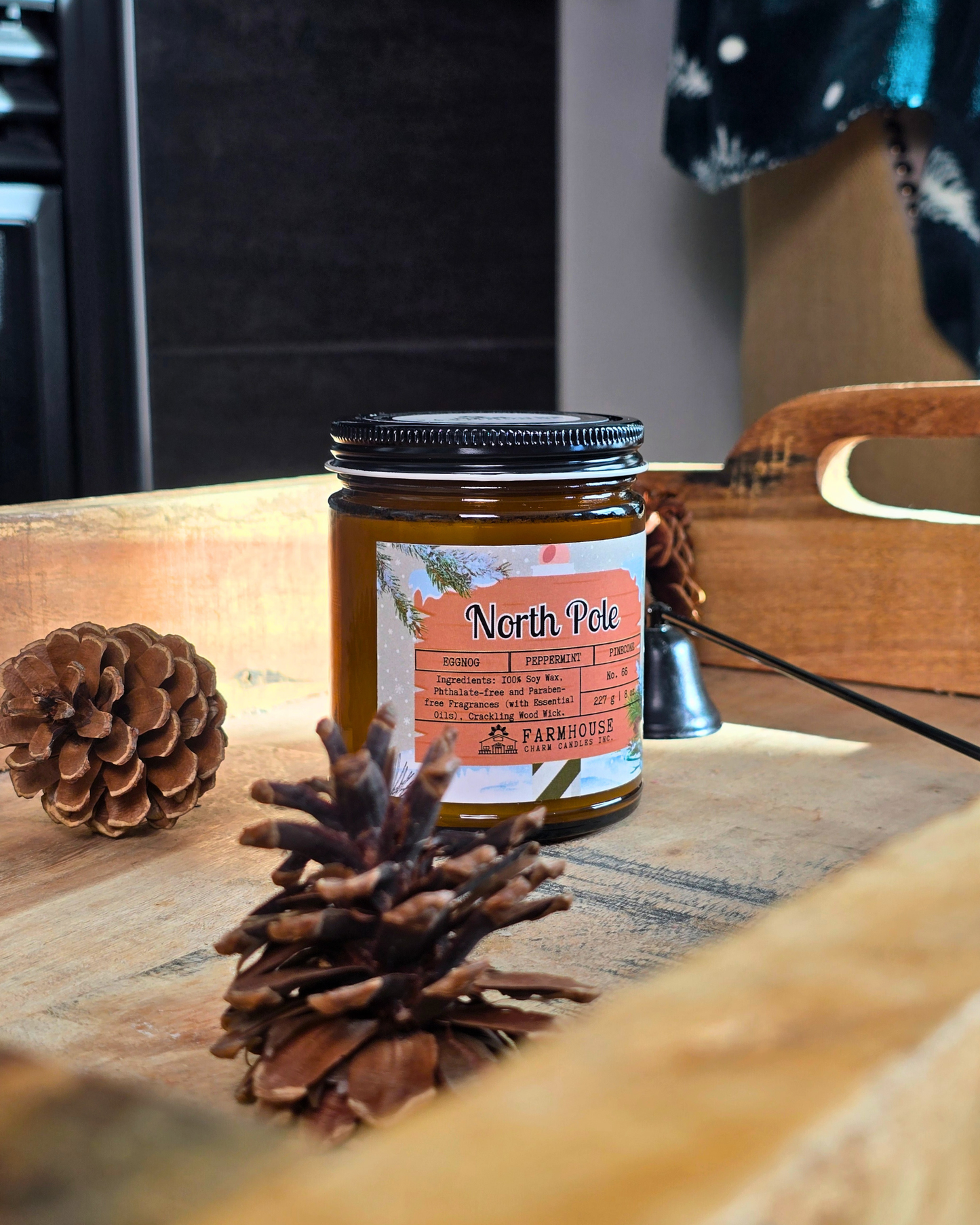 North Pole Soy Candle by Farmhouse Charm Candles — hand-poured soy candle in amber jar with a cozy holiday scent of eggnog, peppermint, and pinecone, styled with festive winter decor.