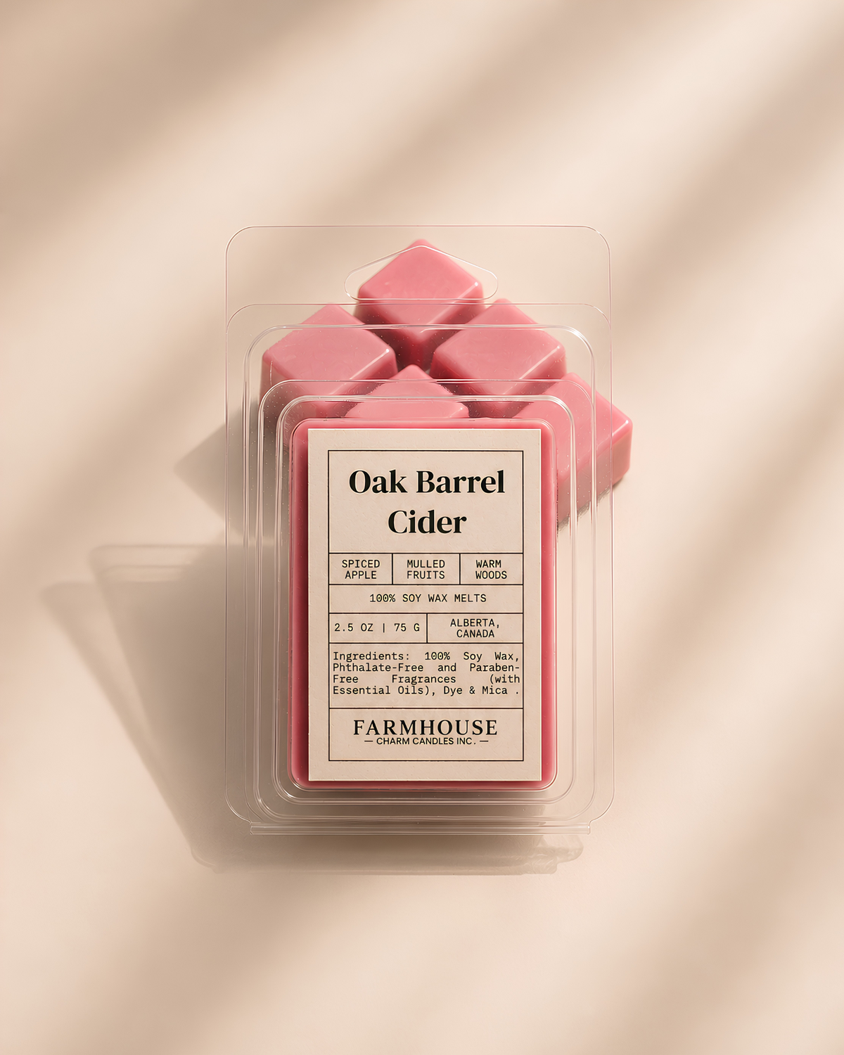 A package of Farmhouse Charm Candles Oak Barrel Cider wax melts, showing several pink wax cubes inside a clear clamshell container with a beige label, set against a warm beige background with soft diagonal shadows.