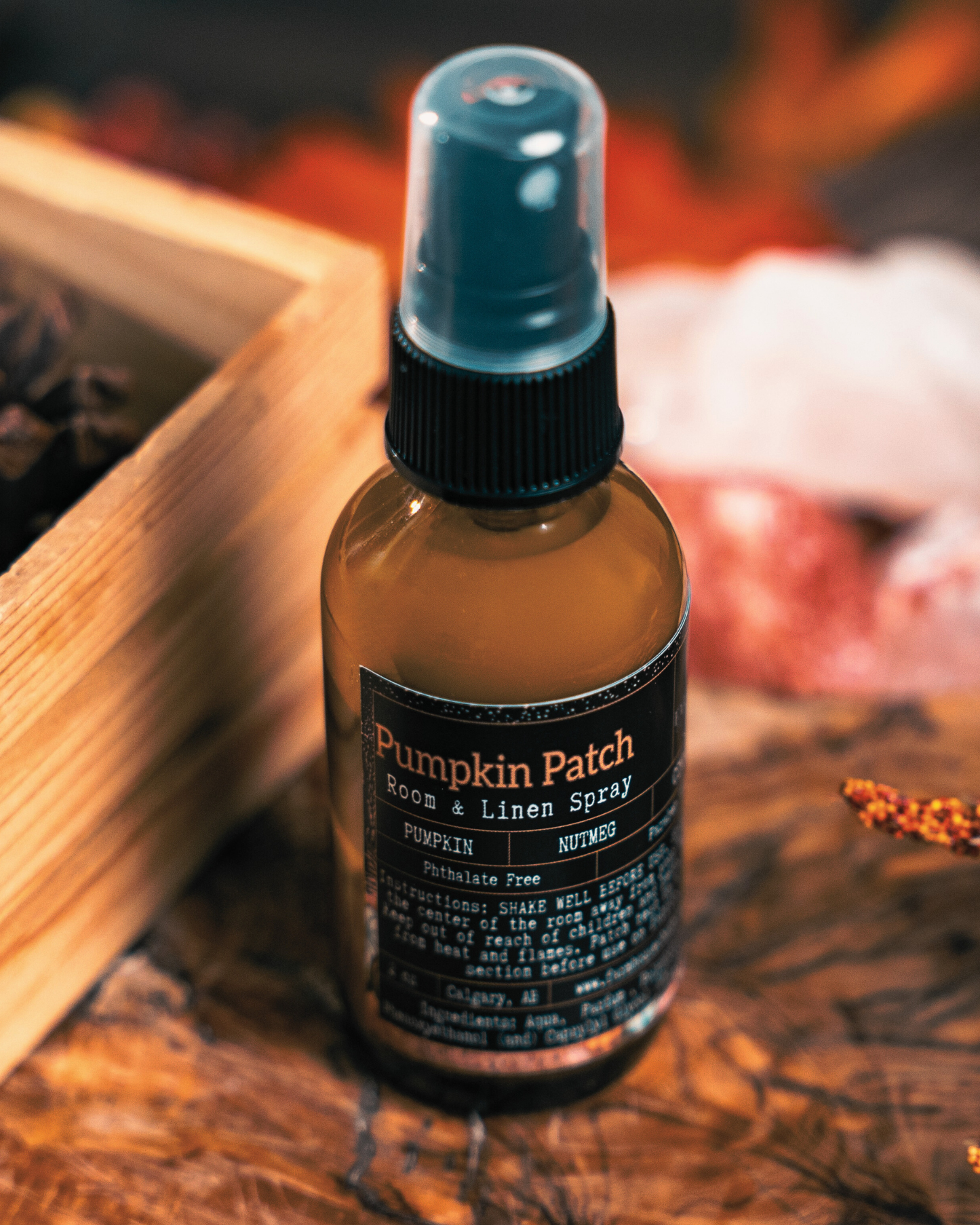 Pumpkin Patch room & linen spray bottle by Farmhouse Charm Candles on a wooden surface with autumn decorations.