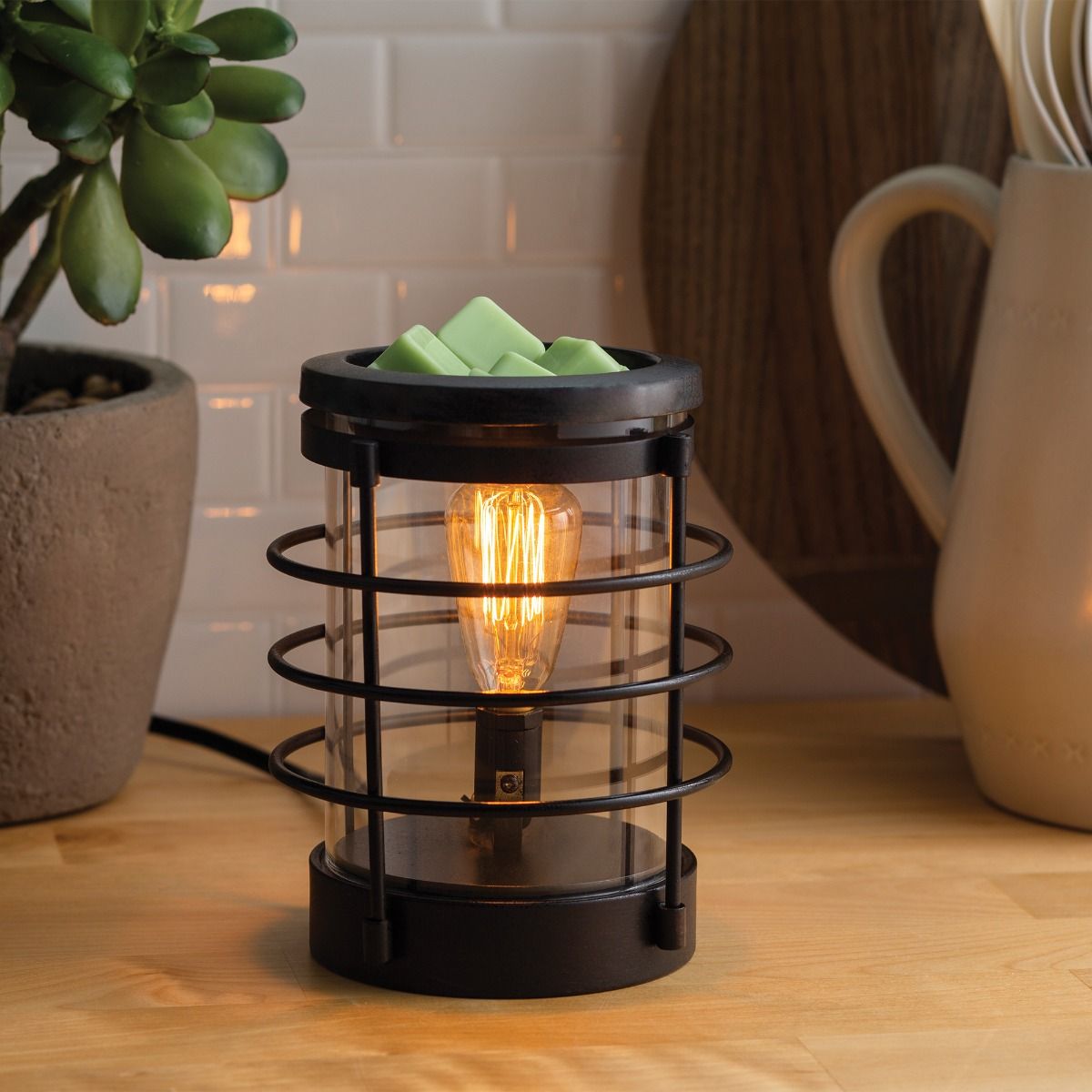 An updated traditional style with wire framing in a matte black finish give this Vintage Bulb Illumination a classic lantern feel. Illumination Fragrance Warmers use a Vintage Bulb to warm wax melts in the dish, releasing their fragrance. Suggested Use: Simply add wax melts to the dish, turn it on, and enjoy your favorite fragrance as it spreads through the room. This warmer works beautifully with 100% Soy Wax Melts by Farmhouse Charm Candles Inc.