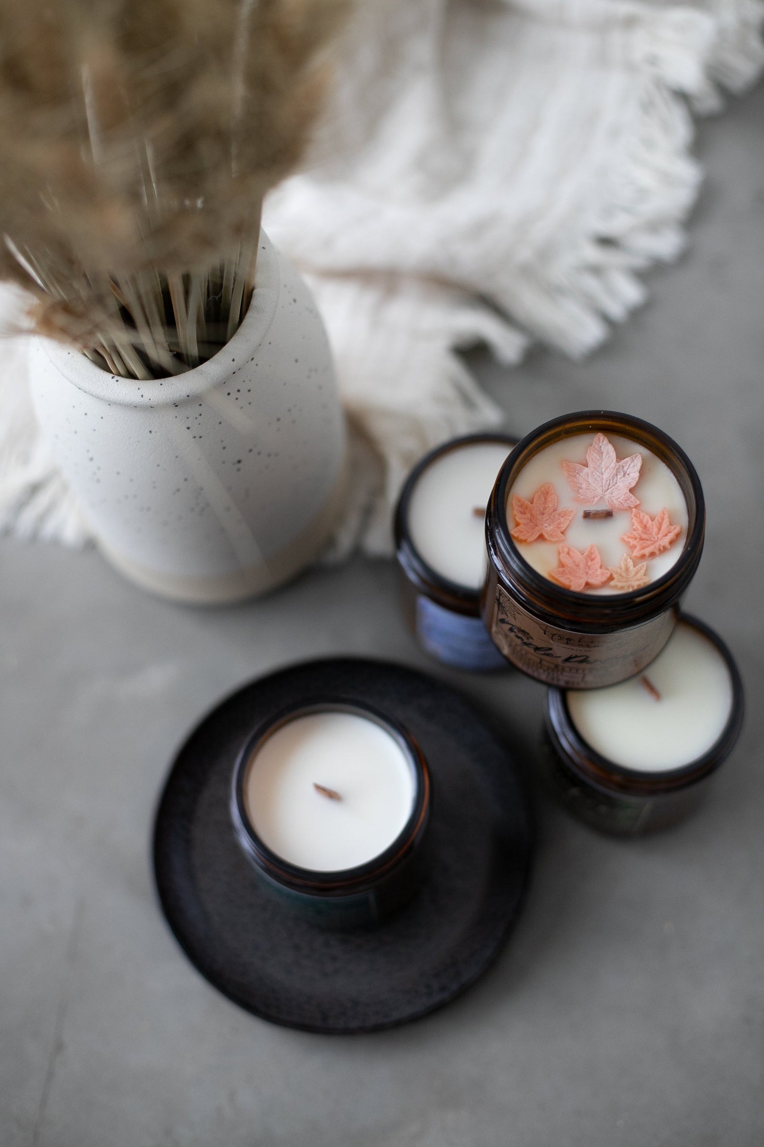 Candles with maple leaves on cozy room setup by farmhouse charm candles