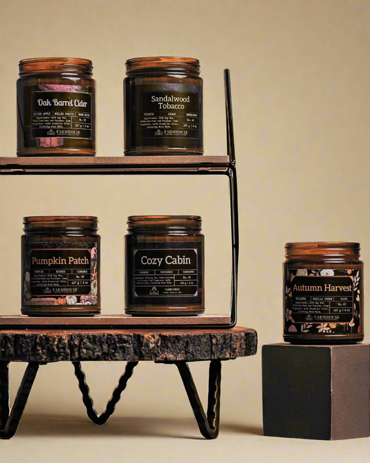 Collection of Autumn Glow Soy candles with labels by Farmhouse Charm Candles on a wooden shelf against a beige background