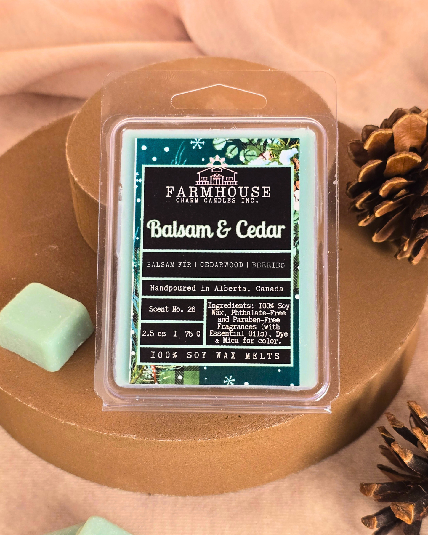 Farmhouse Charm Candles Balsam & Cedar wax melts  on a wooden surface with pinecone.