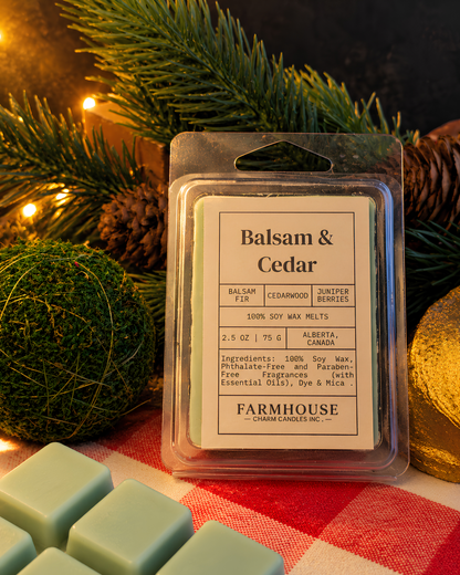 A packaged wax melt product labeled 'Balsam & Cedar' by  Farmhouse Charm Candles, shown in a clear plastic clamshell package with a white label.