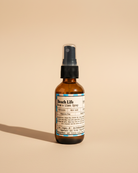 Bottle of Beach Life Room & Linen Spray by Farmhouse Charm Candles on neutral beige background