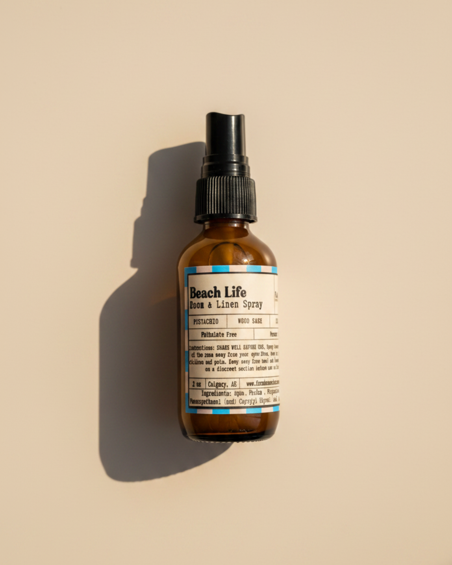 Beach Life room and linen spray bottle by Farmhouse Charm Candles on a warm background