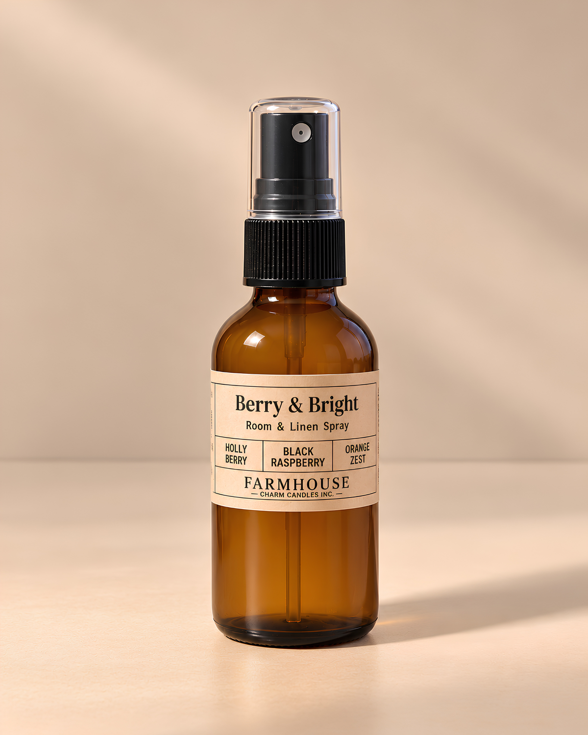 An amber glass room and linen spray bottle with a black spray top and a cream label reading 'Berry & Bright' by FARMHOUSE Charm Candles photographed on a warm beige background with soft shadows.