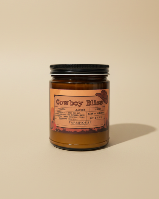  candle in amber jar with wood wick, western label, tobacco/leather/amber notes. Cowboy Bliss by Farmhouse Charm Candles