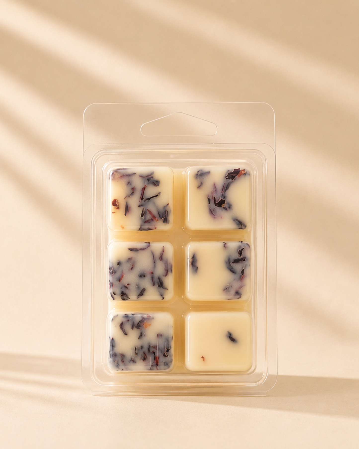 Close-up of 6 cream soy wax melt cubes infused with dried hibiscus petals in clear clamshell packaging, warm beige background — Farmhouse Charm Candles Cowboy Bliss