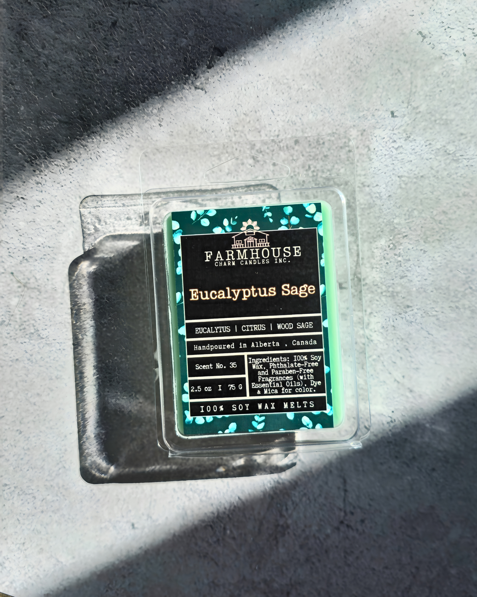 Farmhouse Charm Candles Soy Wax Melts packaging with label "Eucalyptus Sage' on a concrete surface