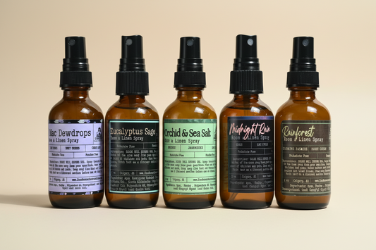 Five bottles of different scented sprays on a beige surface. Farmhouse Charm Candles Room & Linen Spray- Spring collection Bundle