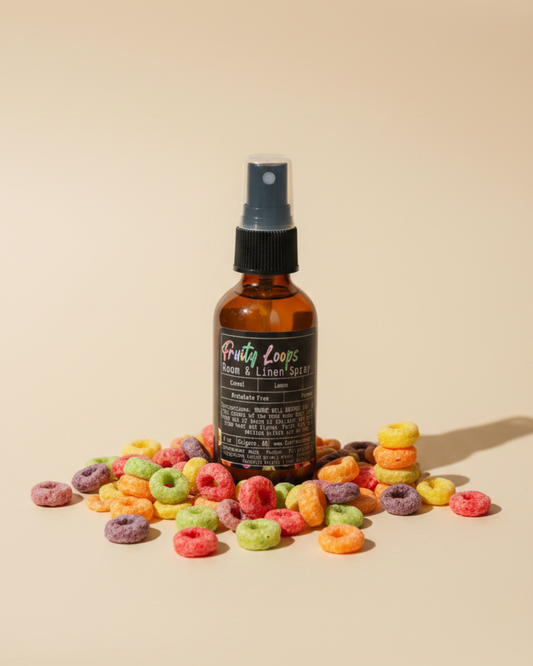 Bottle of Fruity Loops Room & Linen Spray by Farmhouse Charm Candles surrounded by cereal loops on a beige background