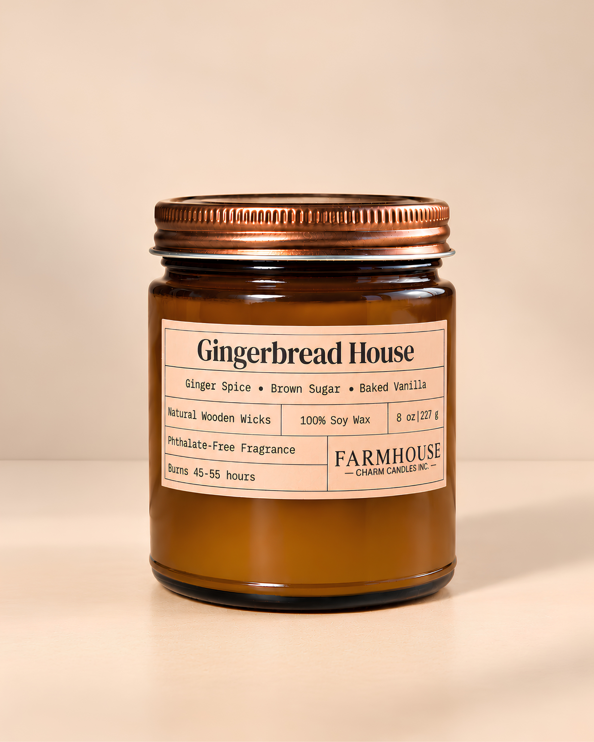 A Farmhouse Charm Candles brand soy wax candle in an amber glass jar with a copper-toned metal lid, labeled 'Gingerbread House' on a warm beige background.