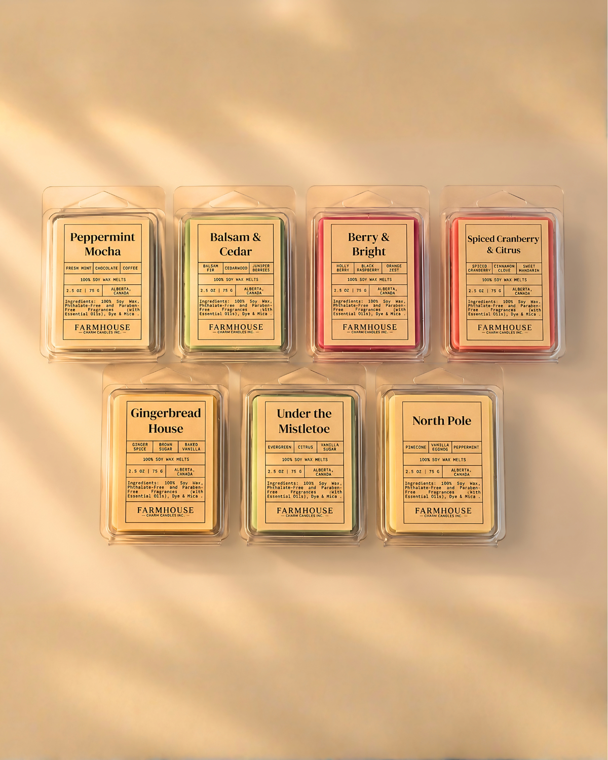 Seven Farmhouse Charm Candles- Home for Christmas Scents wax melts in clear plastic clamshell packaging, arranged in two rows on a warm beige background. The scents include Peppermint Mocha, Balsam & Cedar, Berry & Bright, Spiced Cranberry , Gingerbread House, Under the Mistletoe, and North Pole.