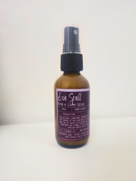 Bottle of 'Love Spell' room and linen  spray by Farmhouse Charm Candles on a white background