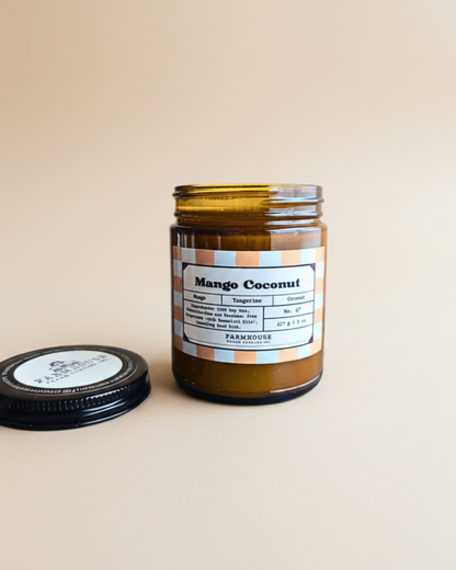Jar of Mango Coconut candle by Farmhouse Charm Candles with a label on a white background