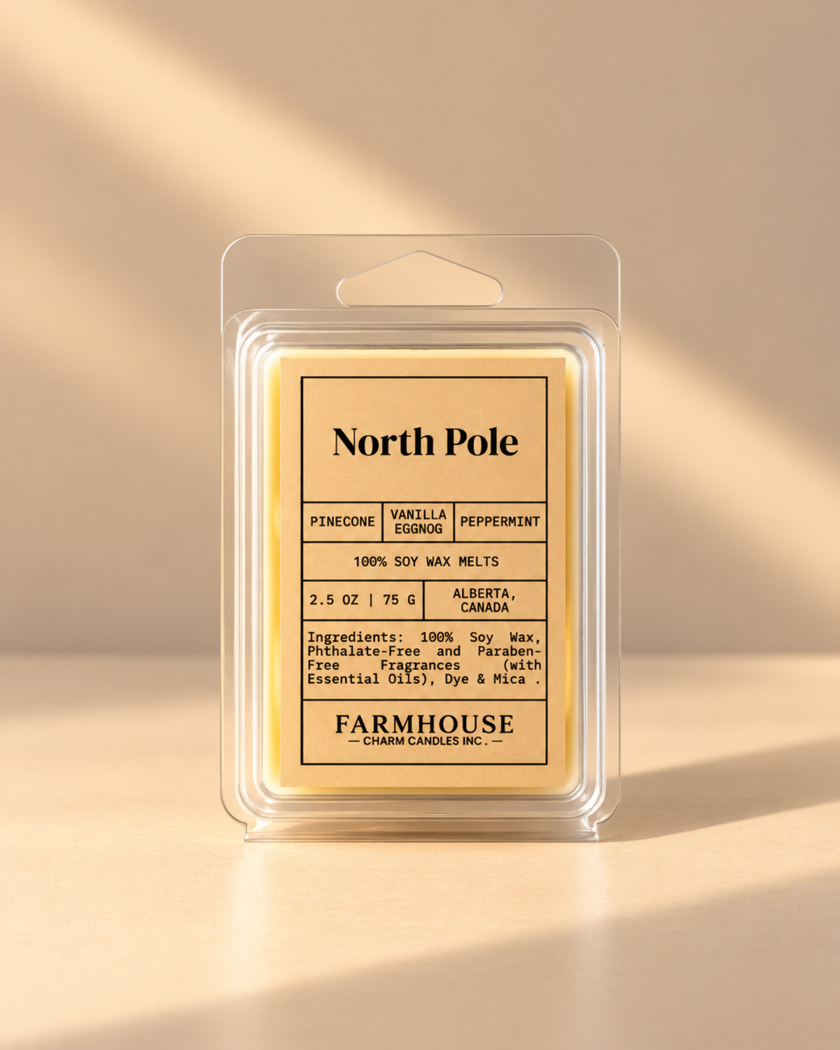 A packaged wax melt product labeled North Pole by Farmhouse Charm Candles in a clear plastic clamshell package with a cream-colored label and pale yellow wax inside, photographed on a warm beige background with soft diagonal shadows.