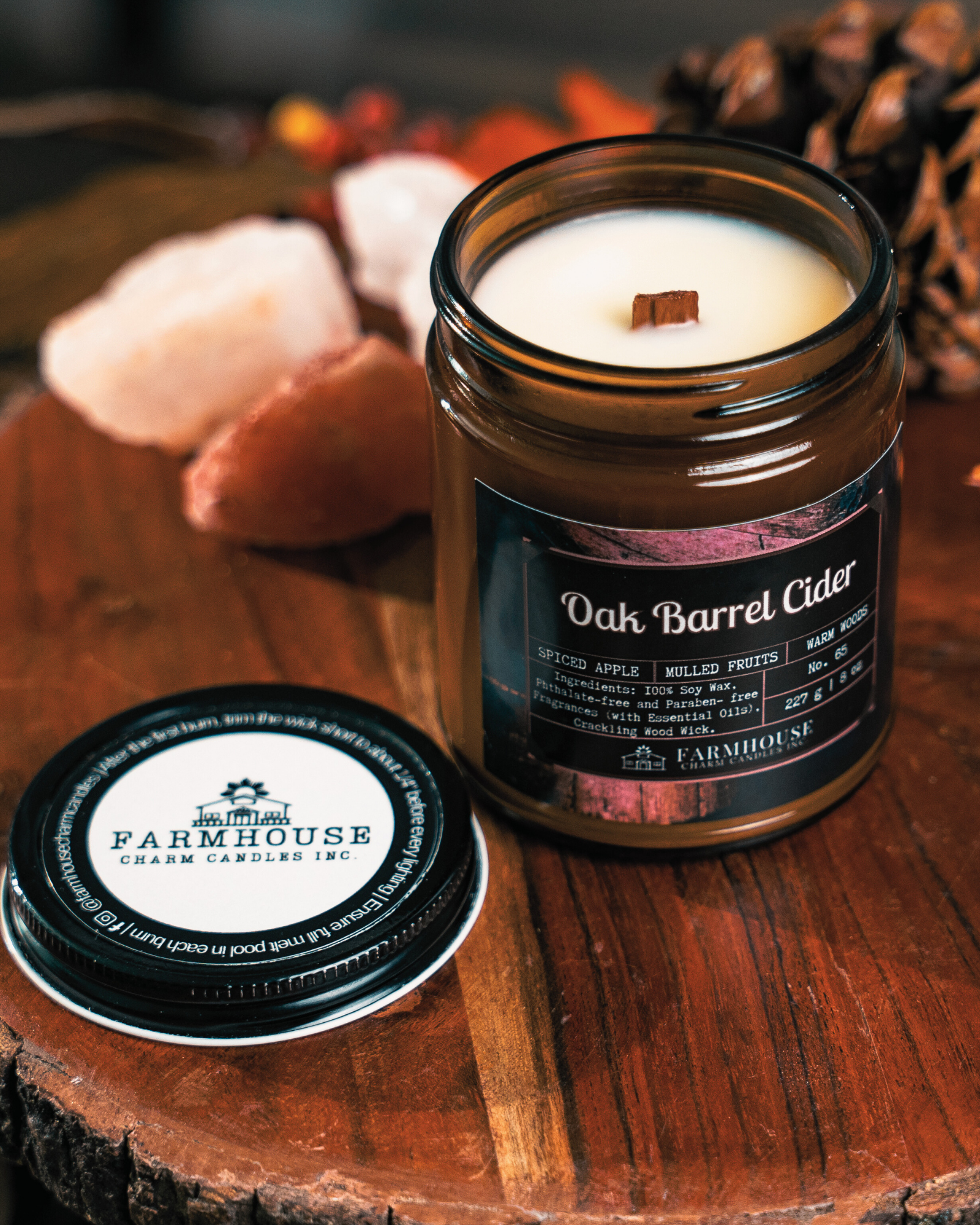 Soy Candle in a jar labeled 'Oak Barrel Cider' on a wooden surface with 'Farmhouse Candles Inc.' branding.