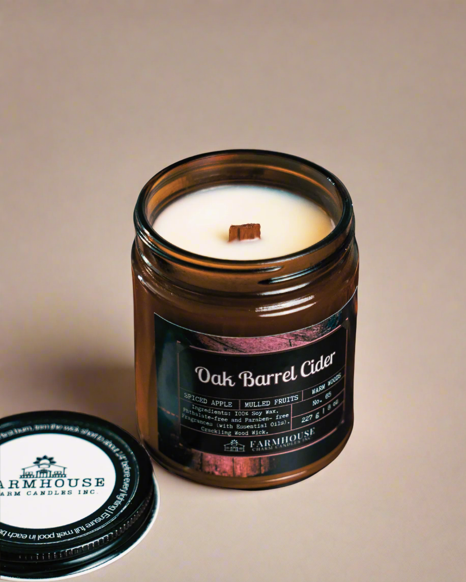 Soy Candle in an amber jar with a label Oak Barrel Cider by Farmhouse Charm Candles on a beige background