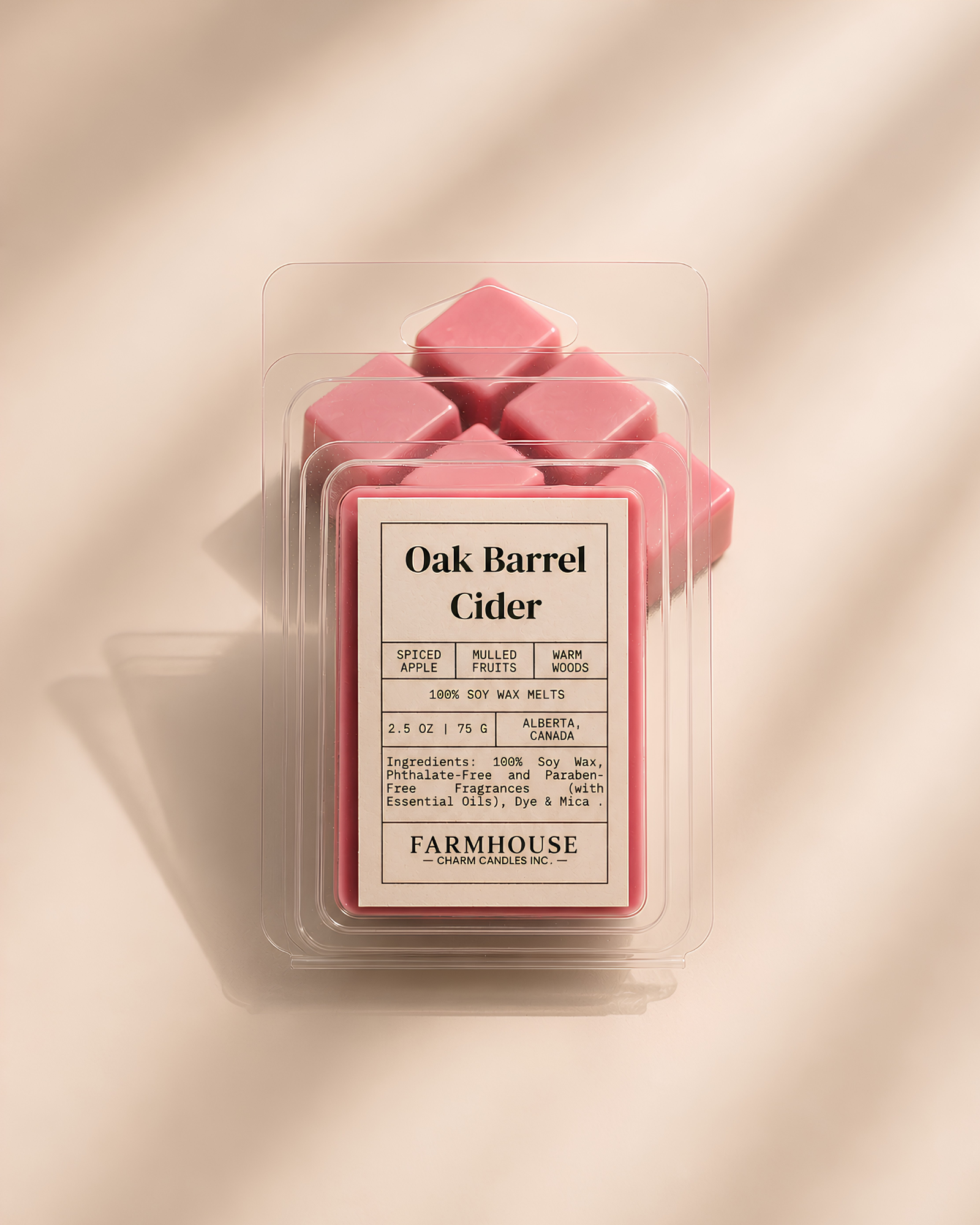 A package of  Farmhouse Charm Candles Oak Barrel Cider wax melts, showing several pink wax cubes inside a clear clamshell container with a beige label, set against a warm beige background with soft diagonal shadows.