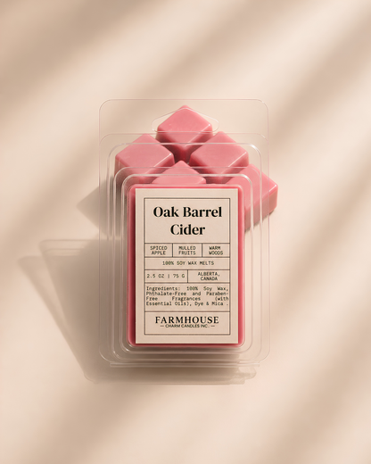 A package of  Farmhouse Charm Candles Oak Barrel Cider wax melts, showing several pink wax cubes inside a clear clamshell container with a beige label, set against a warm beige background with soft diagonal shadows.