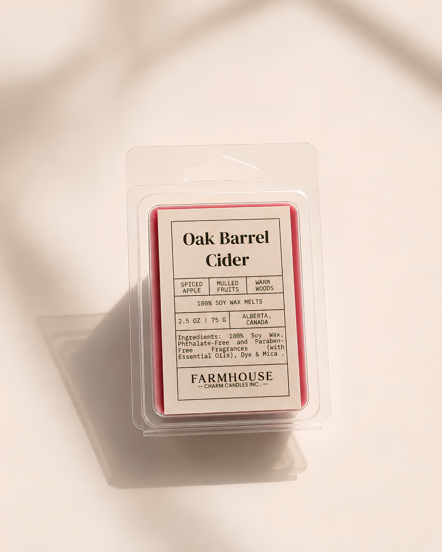 A packaged wax melt in a clear plastic clamshell with a cream label reading 'Oak Barrel Cider'  by Farmhouse Charm Candles photographed on a warm off-white background with soft shadows.