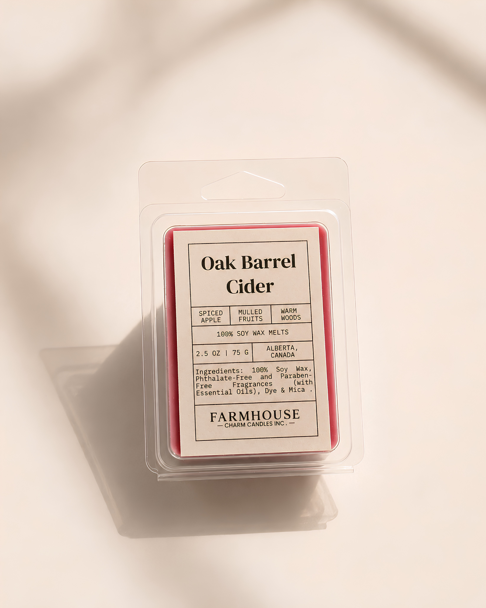 A packaged wax melt in a clear plastic clamshell with a cream label reading 'Oak Barrel Cider'  by Farmhouse Charm Candles photographed on a warm off-white background with soft shadows.
