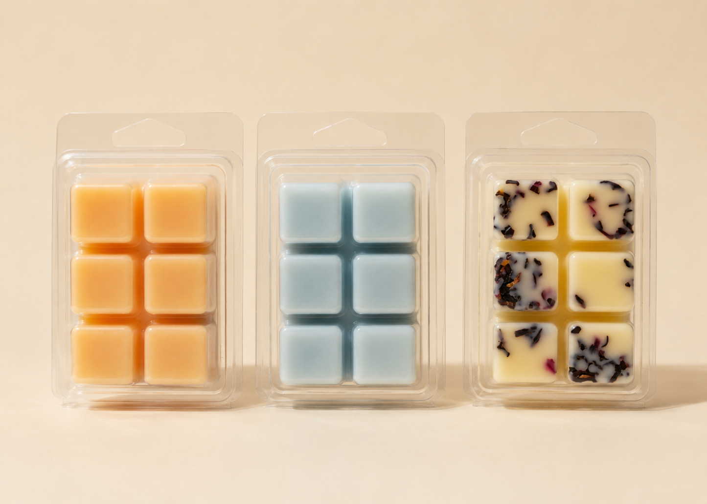 Three soy wax melt clamshells showing wax cube colours — warm golden Maple Eh, soft blue Blue Sky, and cream Cowboy Bliss with hibiscus botanicals — Oh Canada Bundle by Farmhouse Charm Candles