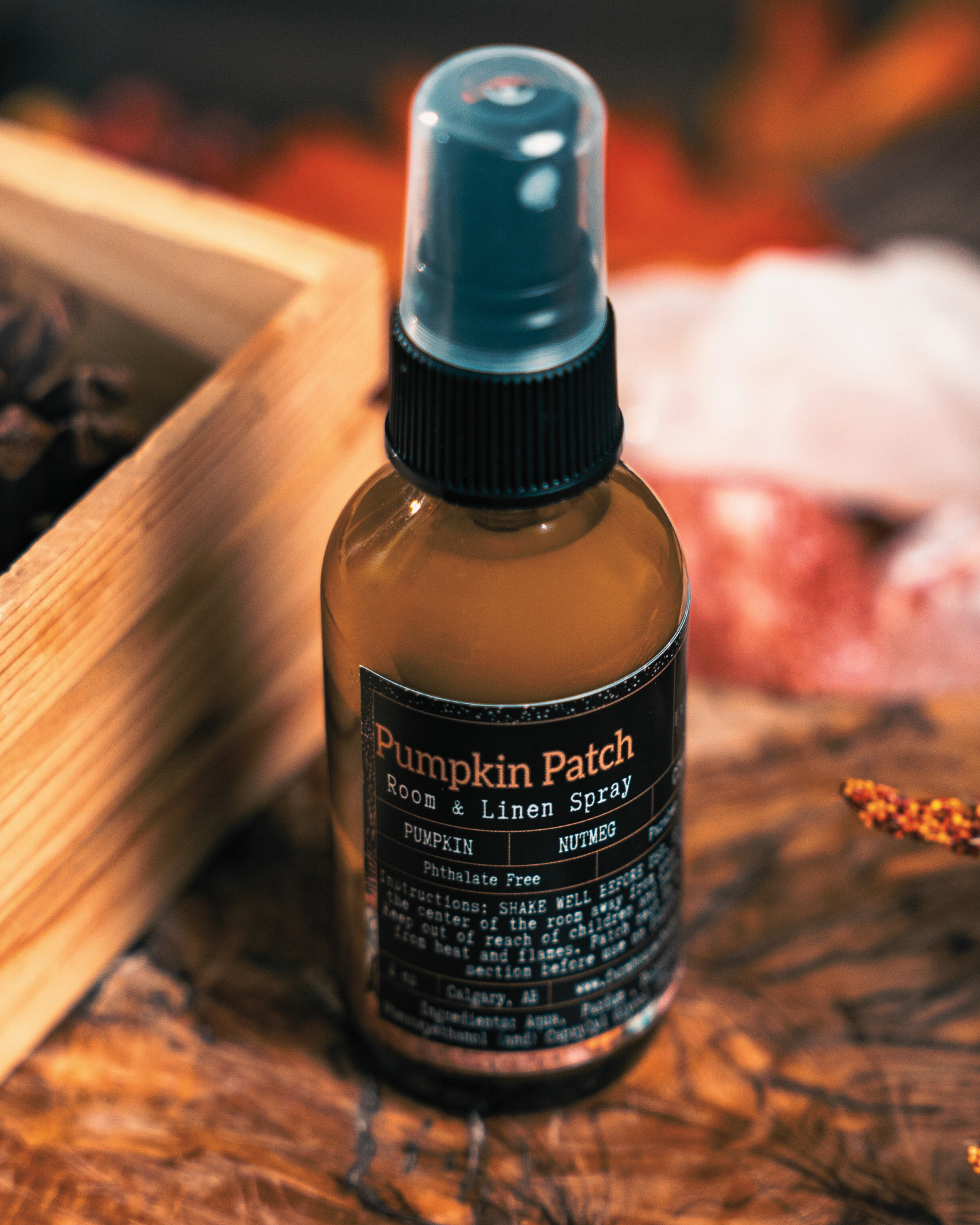 Pumpkin Patch room & linen spray bottle by Farmhouse Charm Candles  on a wooden surface with autumn decorations.