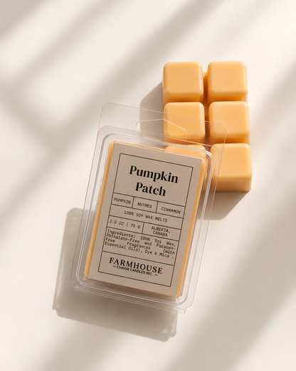 A clear clamshell package labeled 'Pumpkin Patch' by  Farmhouse Charm Candles sits on a white surface with soft diagonal shadows, next to five small square wax melts in a pale pumpkin-yellow color.