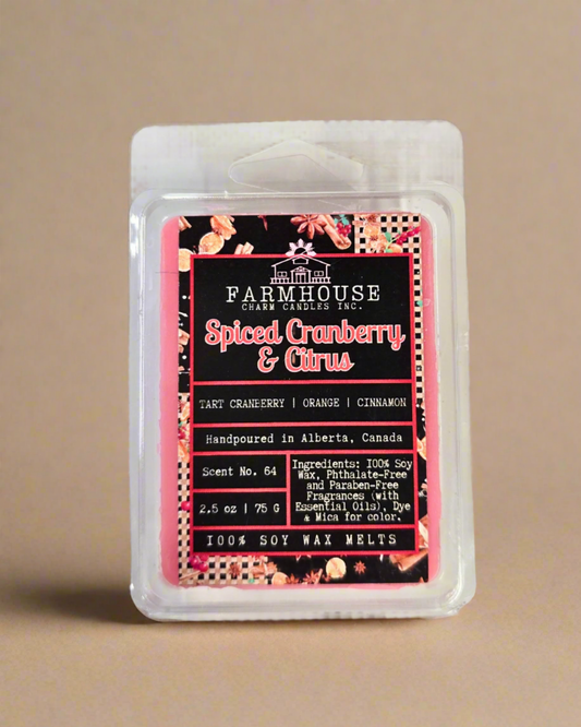Spiced Cranberry & Citrus wax melts in wood style setting, featuring warm tones of red and orange with cozy holiday vibes — a festive blend of tart cranberry, sweet orange, and cinnamon