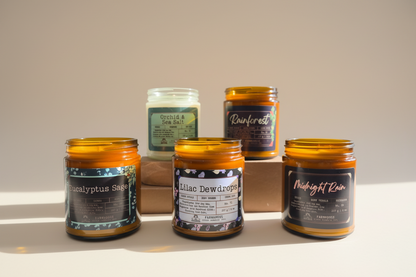 Collection of scented candles with labels on a surface. Spring Candle Set - Farmhouse Charm Candles