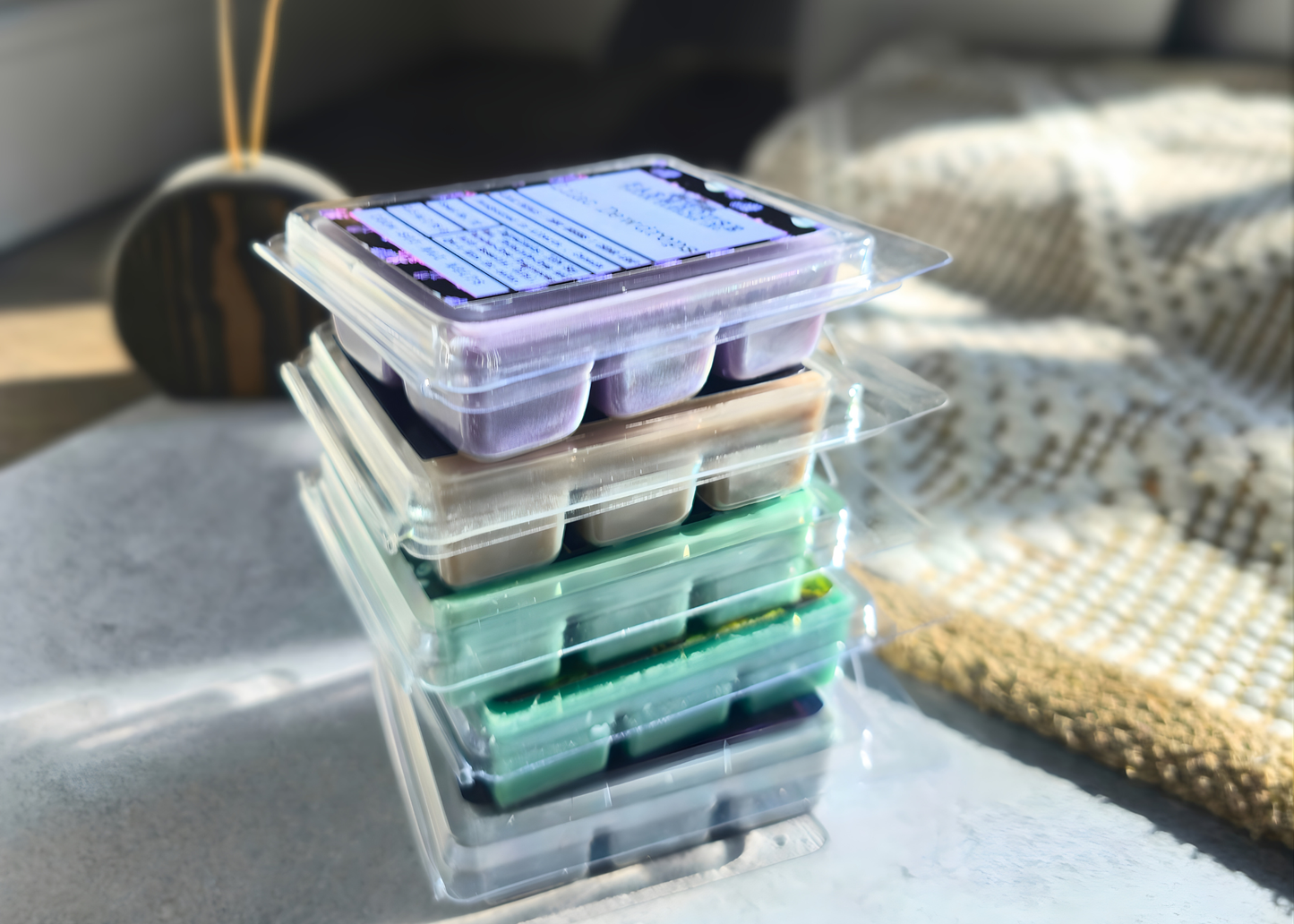 Stack of wax melts on PET clamshell  on a surface with a blurred background. Farmhouse Charm Candles Spring Soy Wax Melt