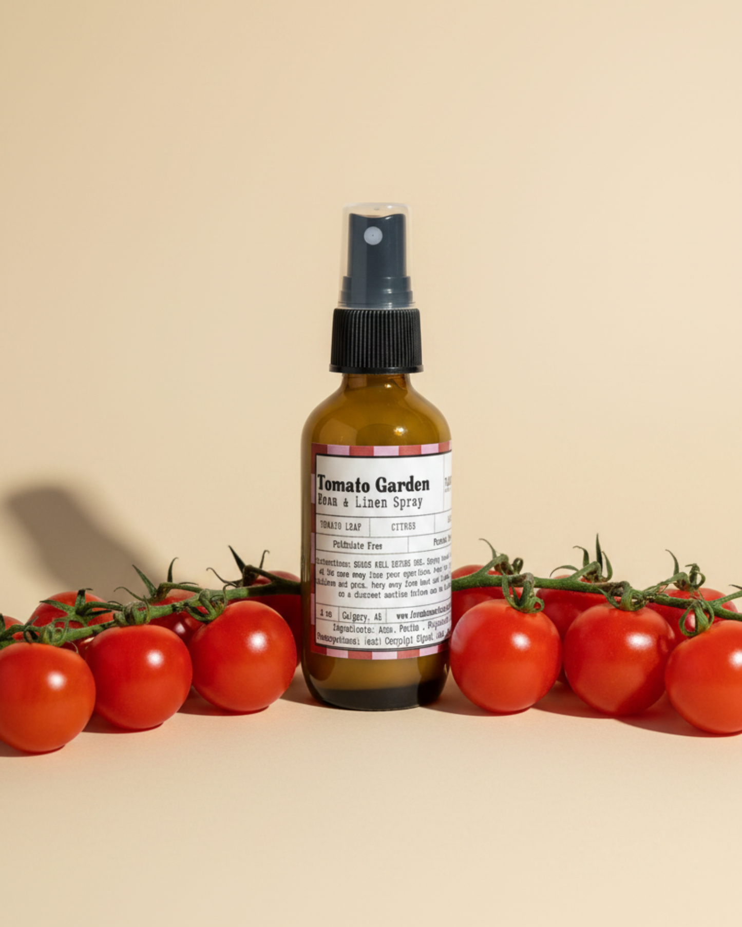 Bottle of Tomato Garden Room & Linen Spray by Farmhouse Charm Candles surrounded by cherry tomatoes on a beige background