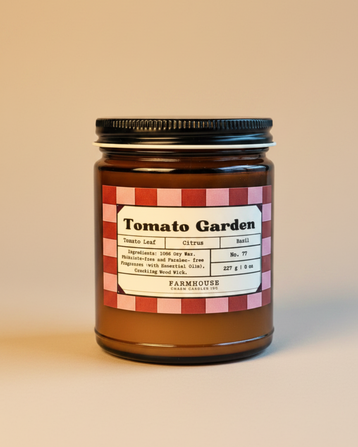 Jar of candle labeled 'Tomato Garden' by Farmhouse Charm Candles on a textured surface with a beige background