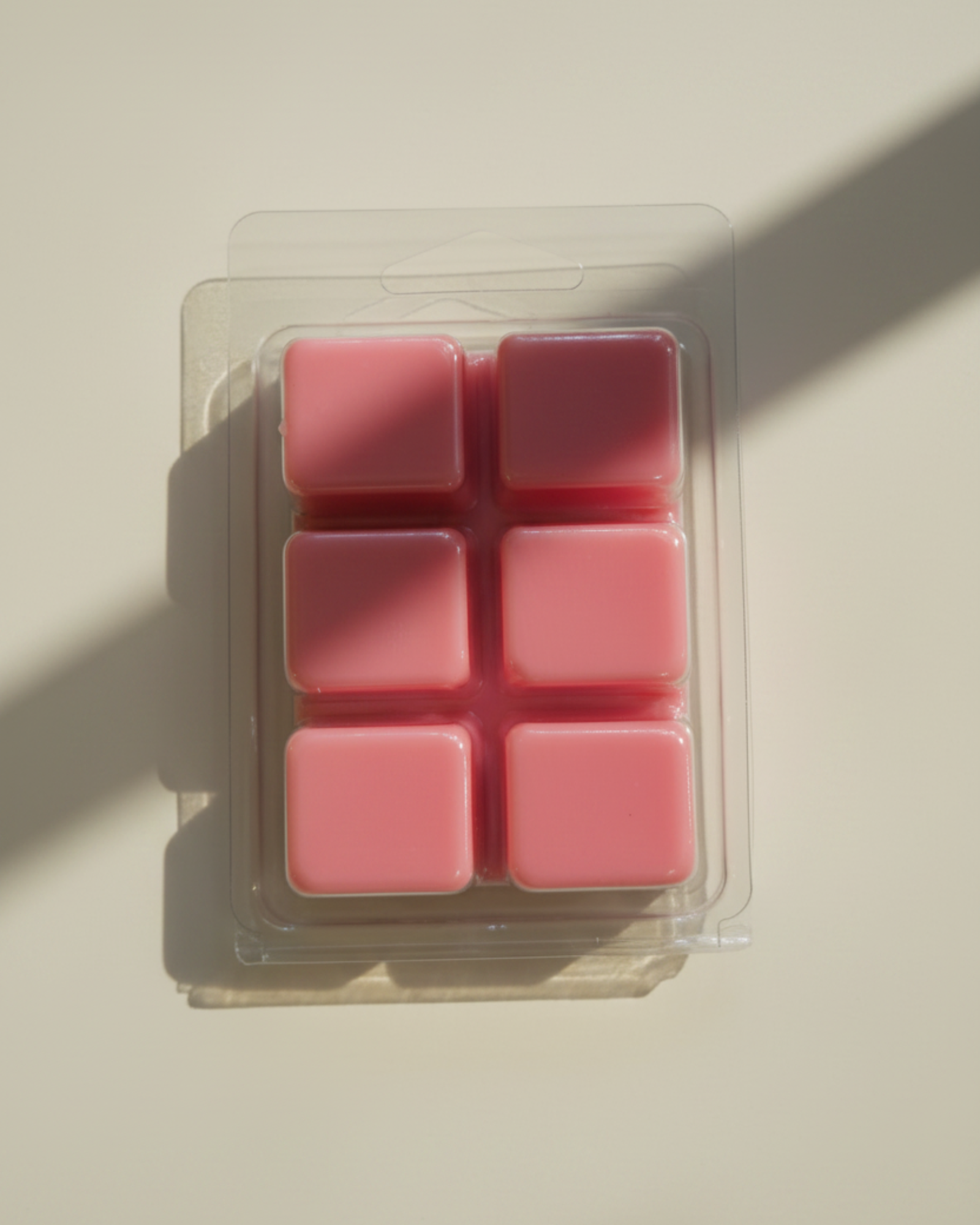 Pack of pink wax melts in a clear plastic packaging on a white background. Tomato Garden wax melts by Farmhouse Charm Candles
