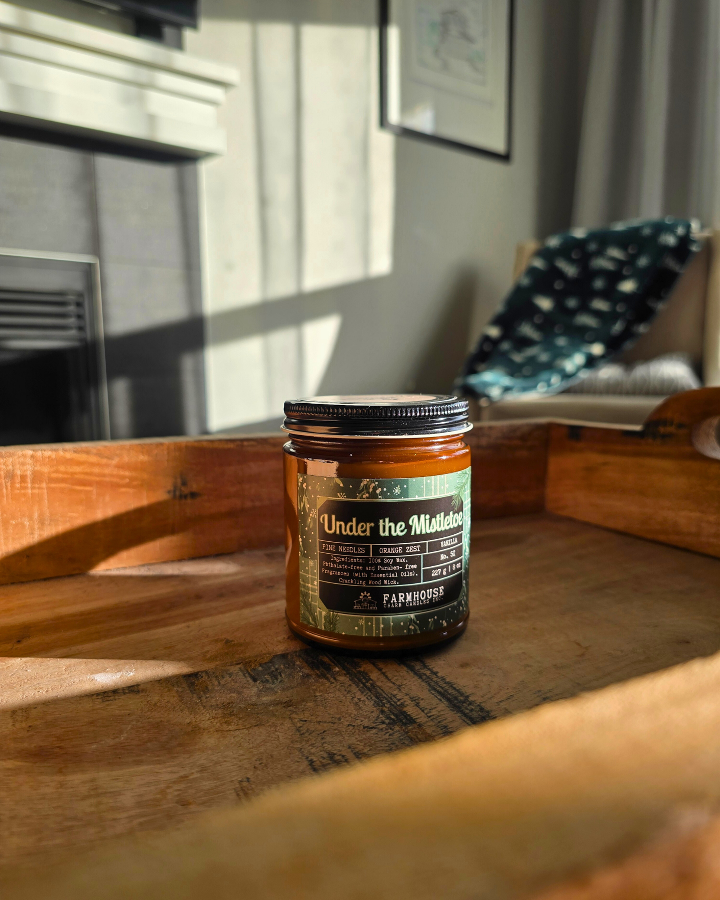 Jar labeled 'Under the Mistletoe by Farmhouse Charm Candles on a wooden surface with a cozy room background