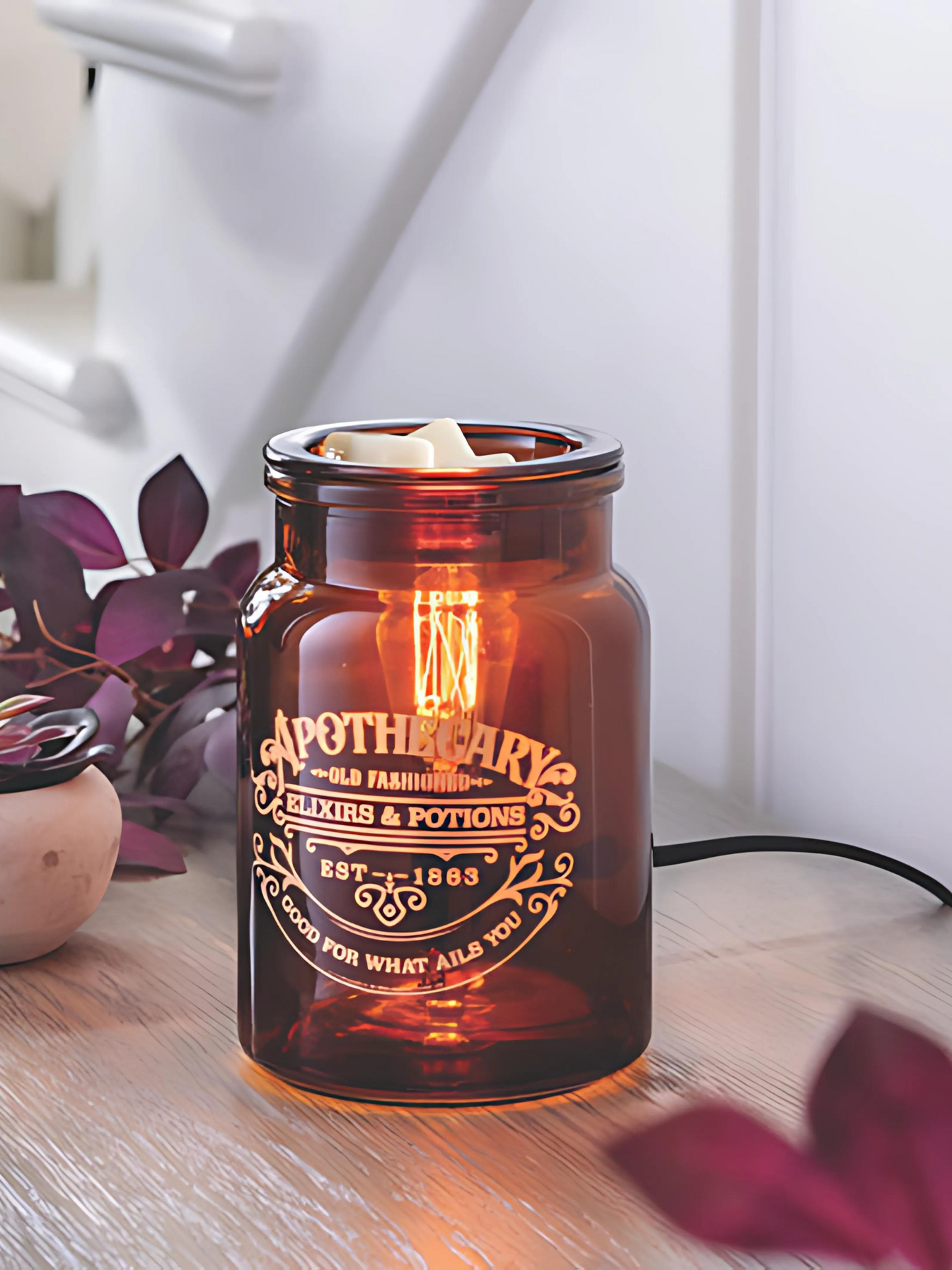 Amber glass Apothecary tart warmer with vintage Edison-style bulb, designed to melt wax safely while creating a cozy dark academia glow, perfect for farmhouse, modern, or traditional decor. www.farmhousecharmcandles.com