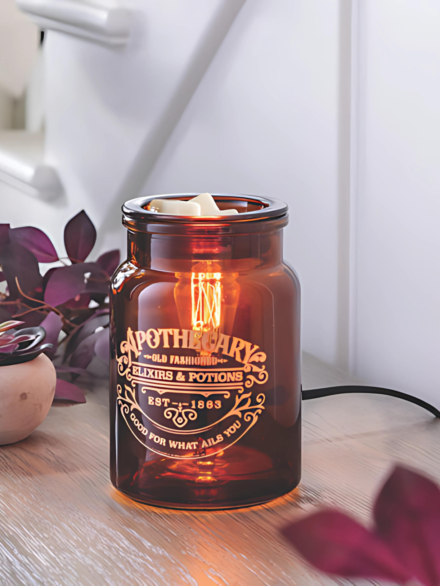 Amber glass Apothecary tart warmer with vintage Edison-style bulb, designed to melt wax safely while creating a cozy dark academia glow, perfect for farmhouse, modern, or traditional decor. www.farmhousecharmcandles.com