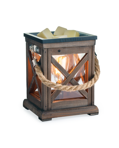 A classic lantern made from espresso toned wood and accented with a rustic rope handle. The traditional x-pattern tops off a slightly coastal feel. Illumination Fragrance Warmers use a halogen bulb to warm wax melts in the dish, releasing their fragrance. Suggested Use: Simply add wax melts to the dish, turn it on, and enjoy your favorite fragrance as it spreads through the room. This warmer works beautifully with 100% Soy Wax Melts by Farmhouse Charm Candles Inc.