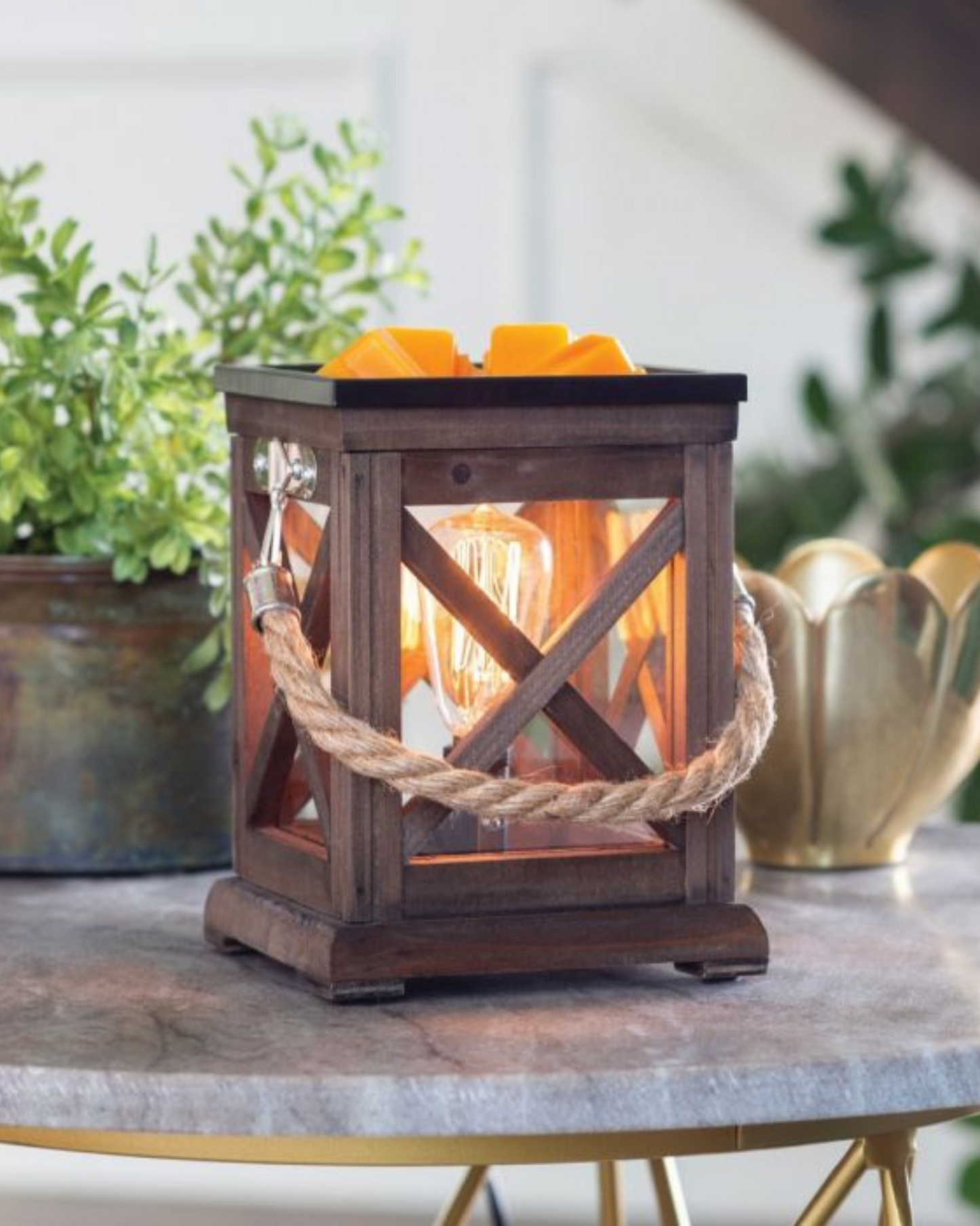 A classic lantern made from espresso toned wood and accented with a rustic rope handle. The traditional x-pattern tops off a slightly coastal feel. Illumination Fragrance Warmers use a halogen bulb to warm wax melts in the dish, releasing their fragrance. Suggested Use: Simply add wax melts to the dish, turn it on, and enjoy your favorite fragrance as it spreads through the room. This warmer works beautifully with 100% Soy Wax Melts by Farmhouse Charm Candles Inc.