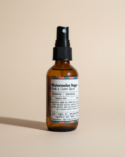 Bottle of watermelon sugar room linen spray  by Farmhouse Charm Candles on a white background